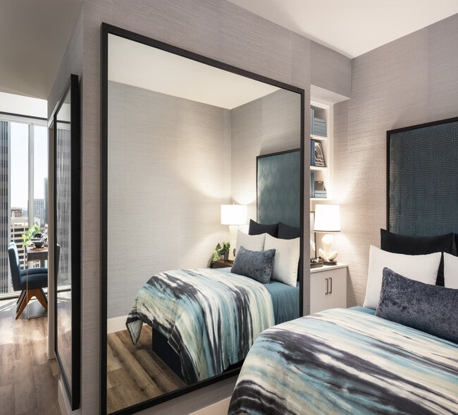 Luxurious bedroom with elegant decor, featuring a plush bed with blue and green accents, modern lighting, and a floor-to-ceiling window offering stunning city views.