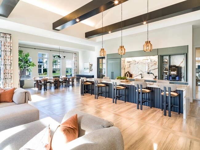 Expansive seating, statement lighting, and sleek finishes define this inviting clubroom with an entertainment kitchen and dining space.