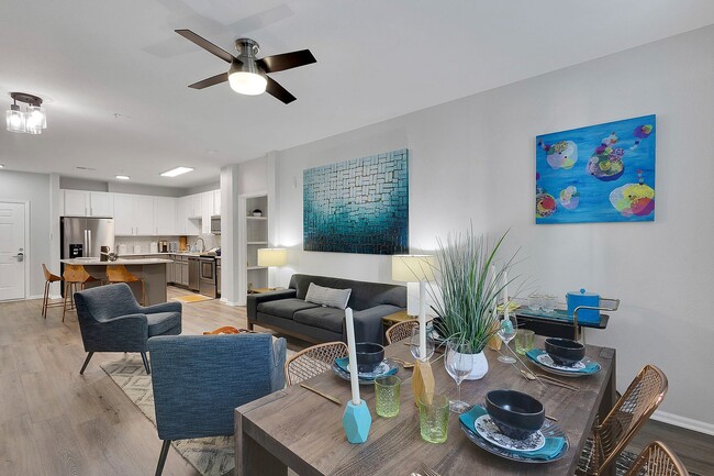 Inviting open-concept living space with modern kitchen, cozy lounge area, and stylish dining setup, perfect for social gatherings.