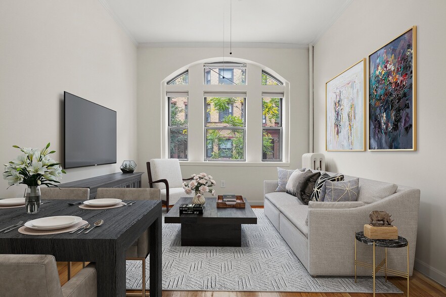 Elegant living room with modern decor, featuring a plush gray sofa, sleek black dining table, and large arched windows offering a beautiful outdoor view.