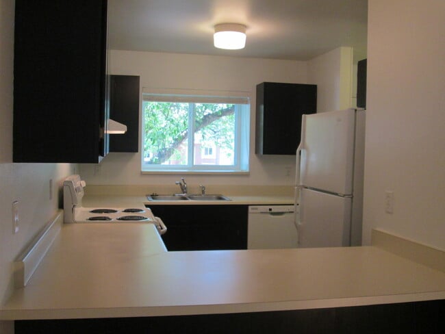 Montones de armarios renovados teñidos en espresso, toneladas de espacio de trabajo en la encimera, electrodomésticos nuevos y área de bar para comer. - 1440 Edora Rd