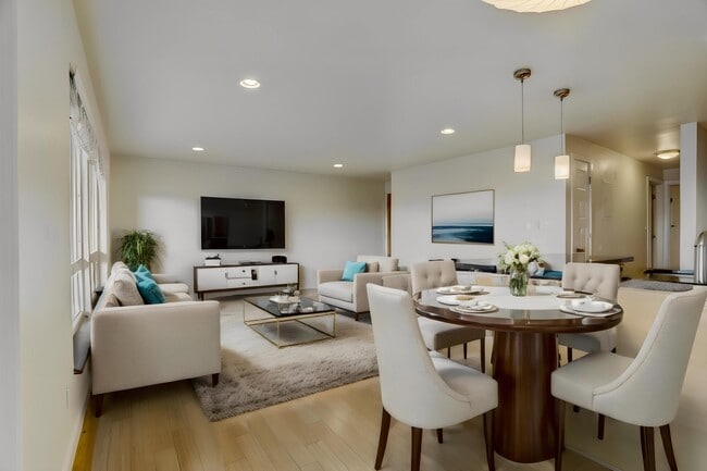 A spacious dining area with a table and chairs, seamlessly connected to a comfortable living room with sofas, creating an inviting space for relaxation and entertainment. - Alaska 45