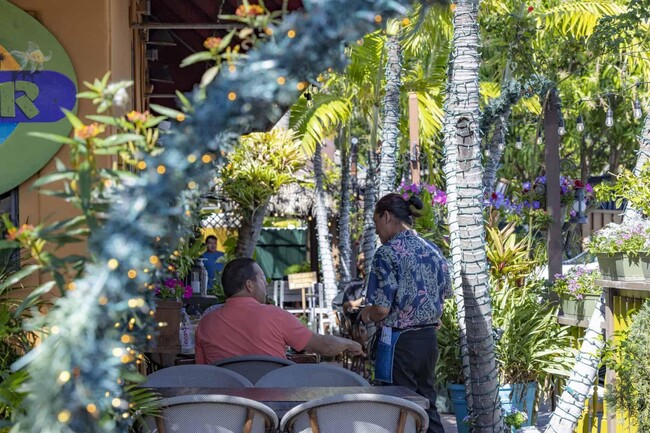 Indulge in a vibrant dining scene at Ponte Verde Apartments At Palm Beach Lakes. Surrounded by lush greenery and a lively atmosphere, it's the perfect spot to unwind with friends. Explore your future home today! - Ponte Verde Apartments At Palm Beach Lakes