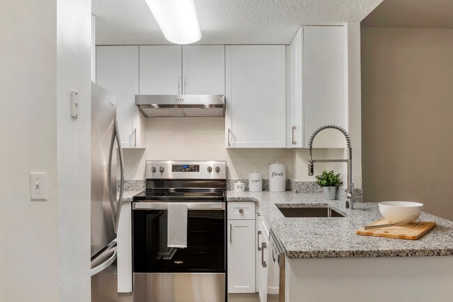 Renovated Package II kitchen with white cabinetry, quartz countertops, stainless steel appliances, and hard surface flooring - eaves Quincy