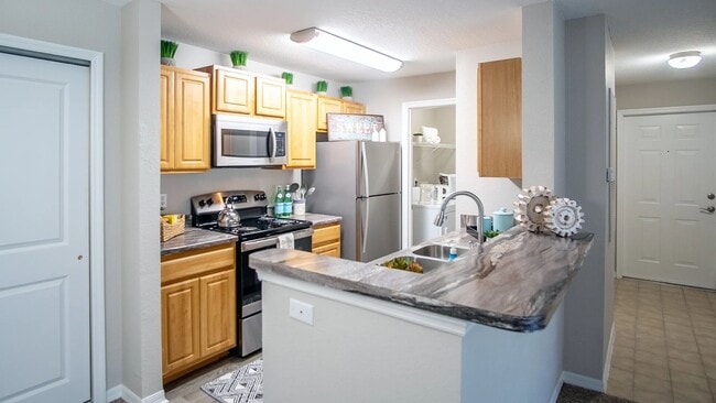 This thoughtfully designed kitchen combines style and functionality with ample storage, modern appliances, and a breakfast bar that overlooks the living space.