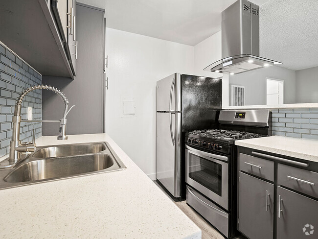 Blue tiled kitchen with stainless steel fridge, oven, and fixtures. - 10620 NoHo Rental