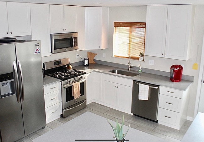 Cocinas actualizadas con electrodomésticos de acero inoxidable. - 5019 W 34th Ave Casa Adosada