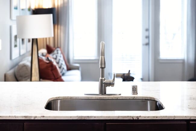 Kitchen with oak cabinetry, granite countertops, tile backsplash, and stainless steel appliances - Avalon Lakeside