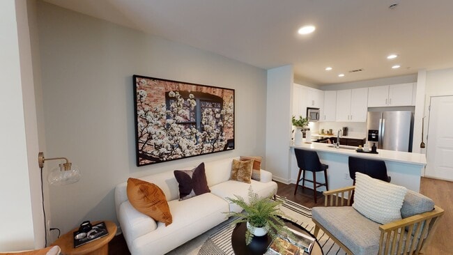 Open kitchen meticulously reimagined with two-tone cabinets, quartz counters, and stainless steel appliances - Alister Montclair Apartments