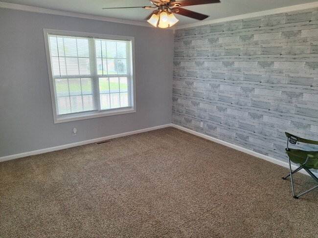 Sala de estar con pared decorativa y ventilador de techo. - 695 Artic Ave