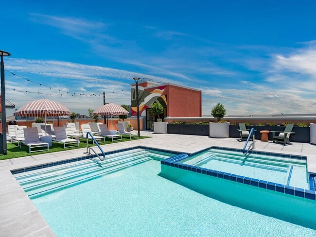 Rooftop pool deck with striped cabanas, lounge seating, and sweeping Tempe views.