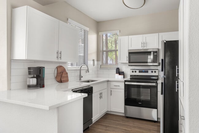 Modern interiors showcase wood-style plank flooring, upgraded cabinetry, quartz countertops with undermount sinks, and stainless-steel appliances