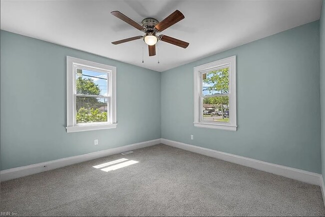 Bedroom with windows and ceiling fan. I added blinds on the windows. - 1003 Douglas Ave