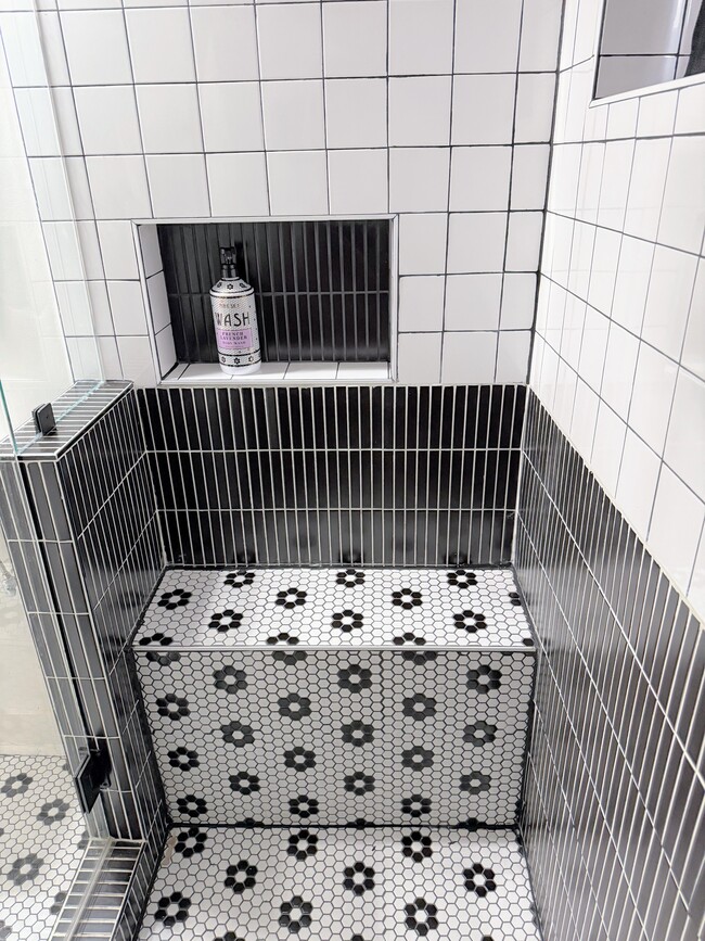 Huge walk in shower with a built in bench and window for natural light