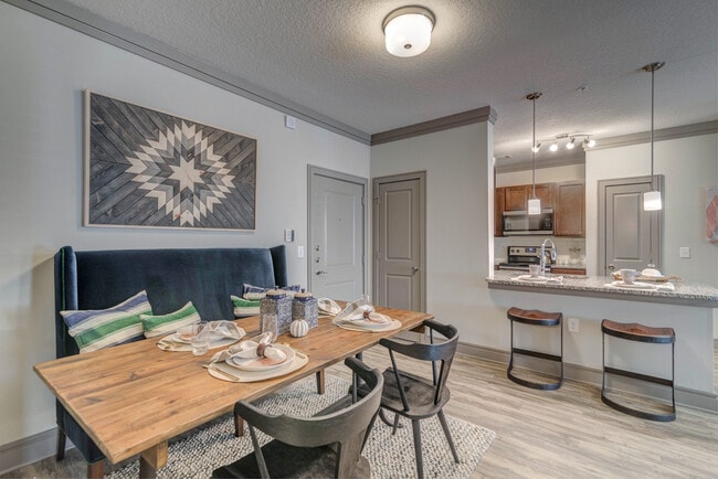 Cocina con iluminación colgante y comedor con suelos de superficie dura - Avalon Mooresville