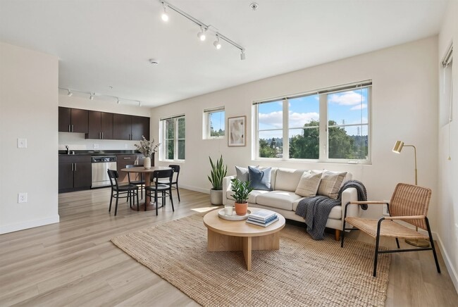 Bright open layout connecting the living room and dining space to the kitchen at REV Fremont in Seattle.