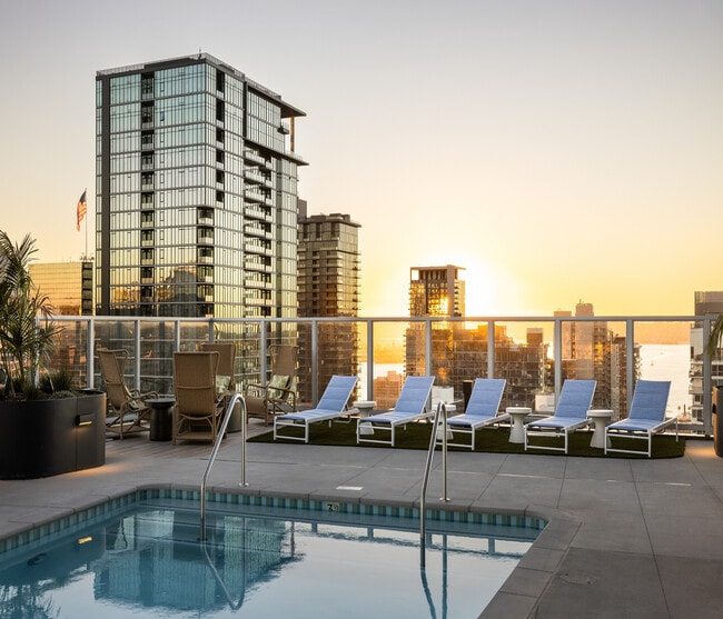 Luxurious rooftop pool with sun loungers and breathtaking skyline views at sunset, perfect for relaxation. - Ancora