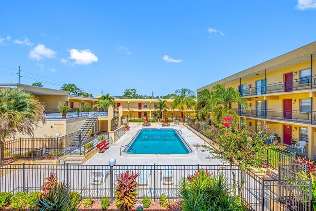Vibrant apartment community featuring a luxurious outdoor pool, surrounded by lush tropical landscaping and modern amenities.