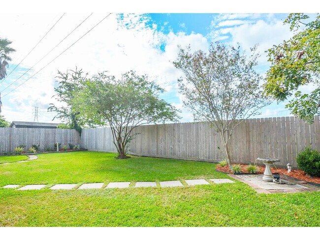 Los patios delantero y trasero están bien cuidados y recientemente se les ha aplicado mantillo. Esta propiedad colinda con una zona verde, ¡así que no hay vecinos en el patio trasero! ¡Organiza reuniones y enciende la parrilla! - 23035 S Waterlily Dr