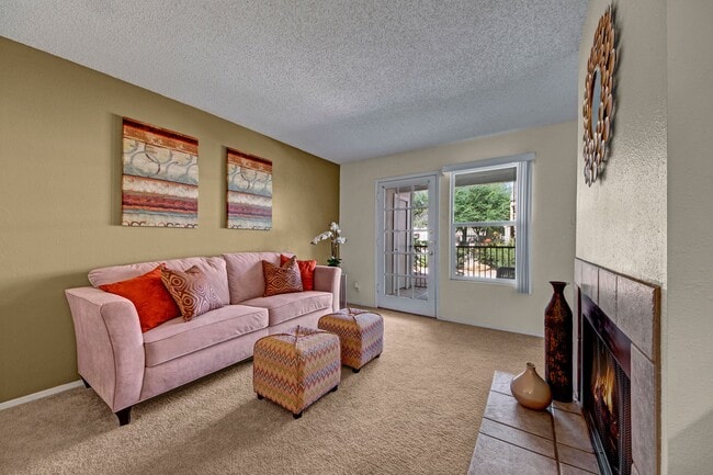A living room with fireplace and glass door out to the patio - Cypress Pointe
