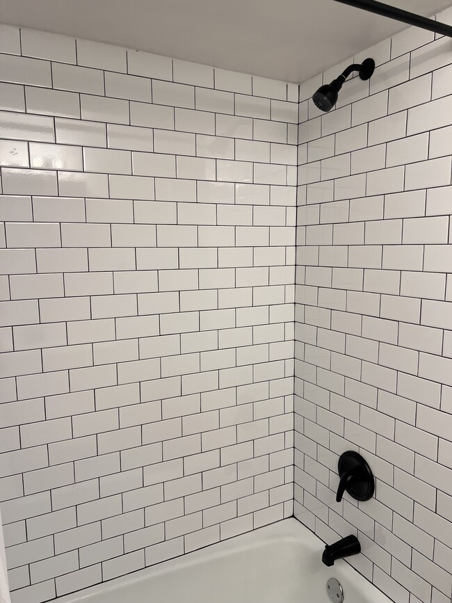 Newly tiled bathtub/shower combo w/ new fixtures - 7220 Madison St Unit 5