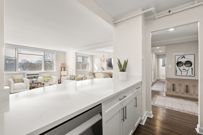 Bright and inviting living space with elegant decor, large windows, and modern quartz kitchen counter detail at Parkside Place, apartments in Cambridge, MA - Parkside Place