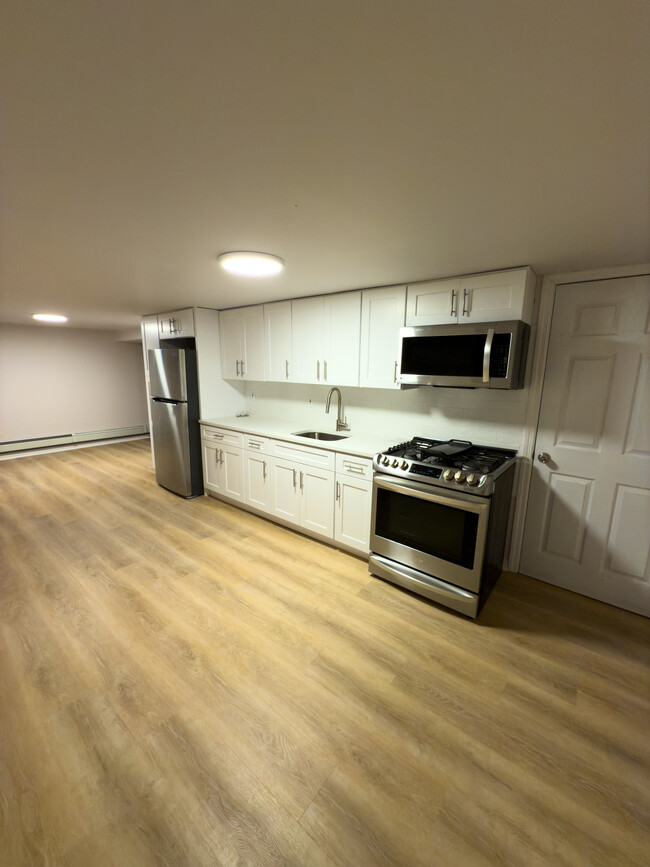 Kitchen/Living Area (Entryway far right corner) - 9517 Rockaway Beach Blvd Apartments Unit Basement