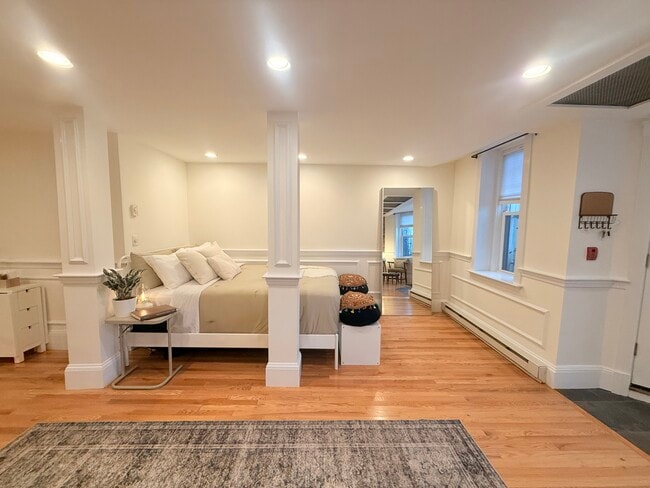living space - view of queen bed from side - 382 Riverway St Unit A