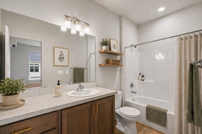 Elegant bathroom with modern fixtures, sleek vanity, and white bathtub, enhanced by warm wood accents.