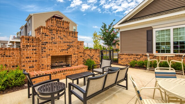 Cozy up to the outdoor fireplace - Valor Apartment Homes