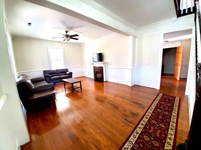 Beautiful large living room with oak wood floors and furnished with quality furniture and smart TV - 526 Monroe St