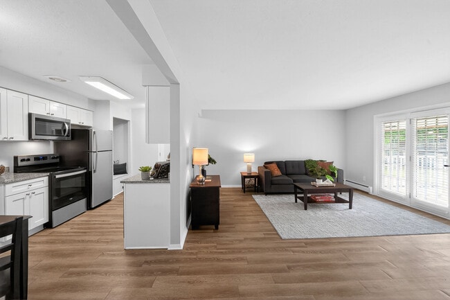 Cocina y sala de estar contemporáneas de planta abierta con electrodomésticos elegantes, suelos de madera noble y abundante luz natural. - University Oaks