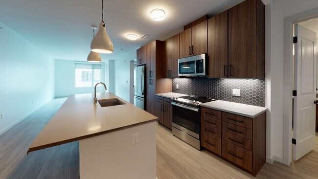 Our alternative option features cozy, chestnut-colored cabinets, paired with a chic, grey designer backsplash and quartz countertops.