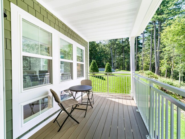 Covered porch with wooded views and room for outdoor seating, extending everyday living into Weston’s natural surroundings.