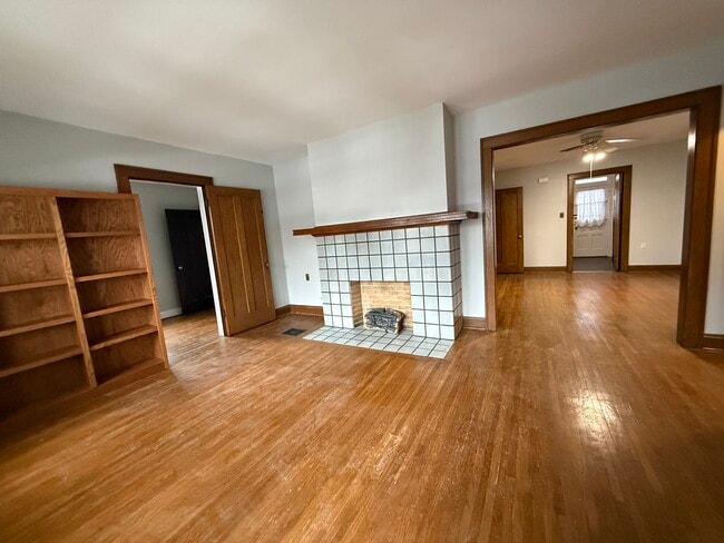 Living room with bookcases and electric logs in fireplace opening - 40 W Tompkins St Unit 40