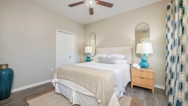Immerse yourself in the plush serenity of our roomy guest bedroom, where wood-style flooring and a whimsical ceiling fan is everything you desire. Indulge in the comforts of this delightful retreat.