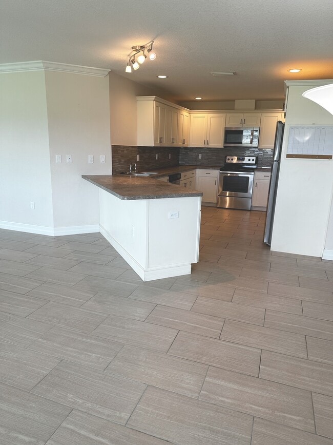Kitchen has lots of cabinets and tile backsplash