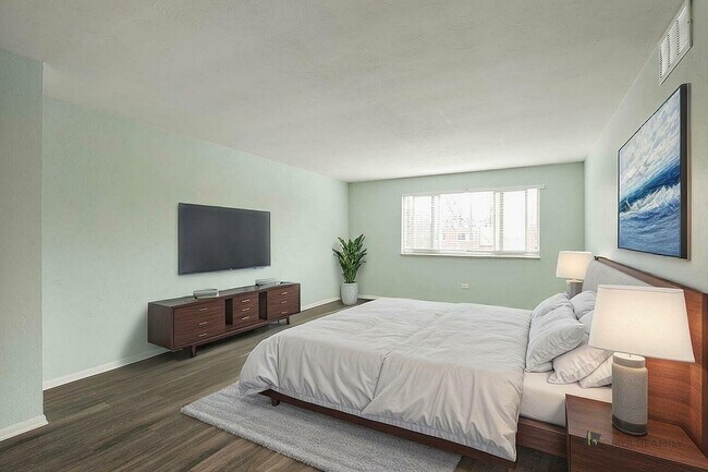 Inviting bedroom with soft green walls, featuring a cozy bed, modern wooden furniture, and a large window letting in natural light. - LaRonja Apartments