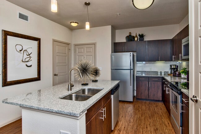 Classic Package I kitchen with espresso cabinetry, speckled granite countertops, white subway tile backsplash, stainless steel appliances, and hard surface flooring