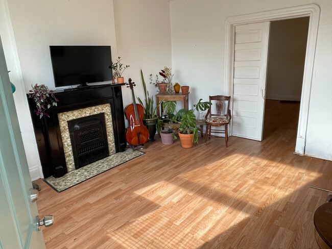 Front, south facing room. Featuring a decorative fireplace & pocketdoor. - 5313 Magnolia Ave Apartments Unit 5313