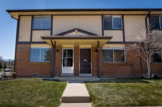 Step into comfort with this charming townhouse featuring a classic brick exterior and lush green lawn. - 10756 West 12th Lane