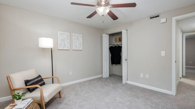 Your bedroom, a timeless space of elegance with plush carpeting, a ceiling fan, and a roomy closet.