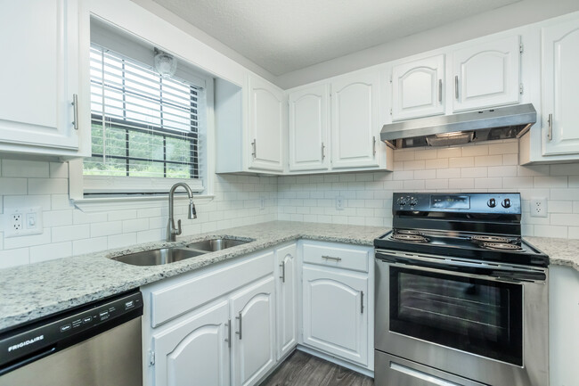 Gorgeous Granite Countertops with Modern Subway Tile Backsplash paired with White Cabinets - Woodland Manor Apartments