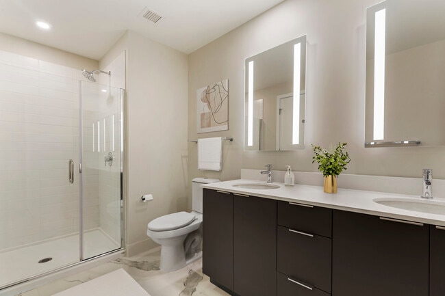 Renovated Package I bath with white quartz countertops, grey cabinetry, and hard surface flooring
