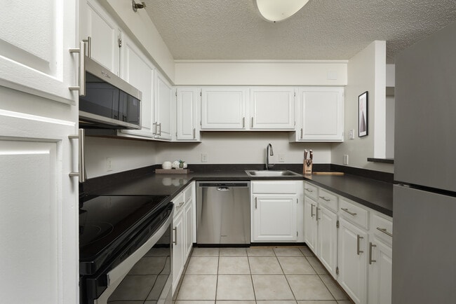 Finish Package II kitchen with white cabinetry, stainless steel appliances and tile flooring