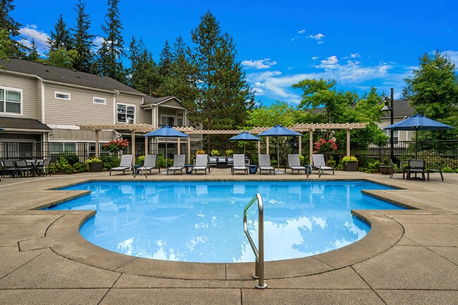 Large pool deck with lounge chairs - The Lodge at Redmond Ridge Apartments