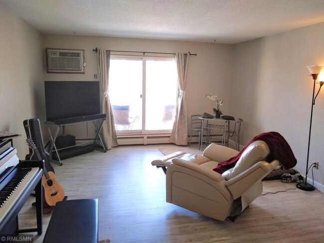 Living room with balcony looking over green space and courtyard - 7414 W 22nd St Unit #302