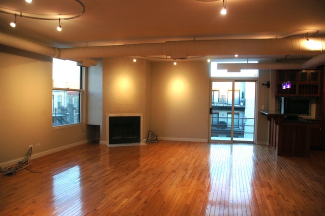 Living room w/Fireplace and adjacent 100 sqft private deck - 525 N Ada St Unit 47