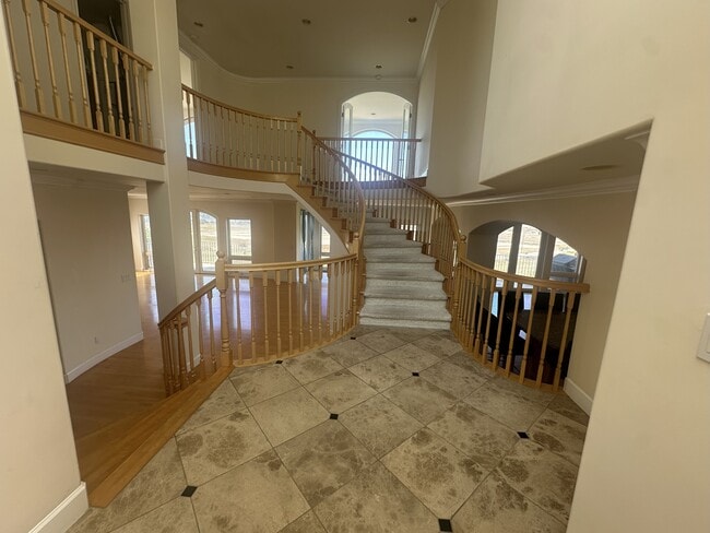 Grand dual staircase with elegant wood railings and carpeted steps anchors this multi-level home. - 8120 Billowvista Dr