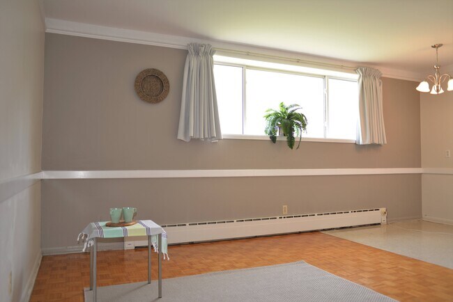 Open-concept living and dining space with bright natural light at Rossmere Manor, 359 Edison. - 359 Edison Avenue